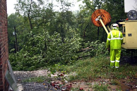 A CDE Lightband worker moves a boom truck into place to repair a power line ripped off a residence by a falling tree in the Idaho Springs neighborhood near Dunbar Cave Road.