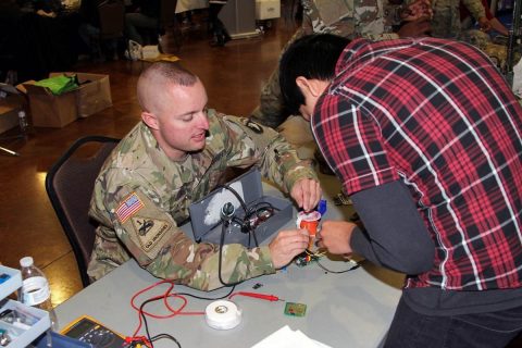 Sgt. 1st Class David Taylor, an electronic maintenance noncommissioned officer with the 101st Airborne Division (Air Assault) Sustainment Brigade, 101st Abn. Div., shows a student the components of a device, Nov. 15, 2017, during Clarksville-Montgomery County School System’s annual Eighth-Grade Career Exploration Day at the Wilma Rudolph Event Center in Clarksville, Tennessee. (Spc. Alexes Anderson/101st SBDE Public Affairs)