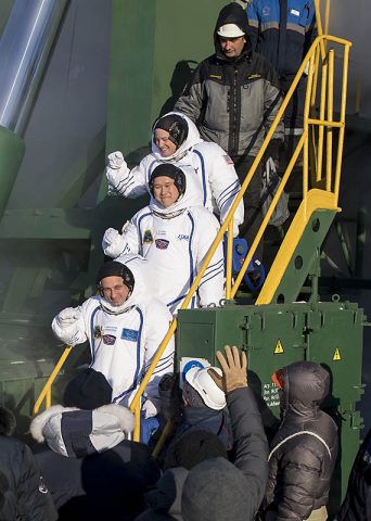 Expedition 54 flight engineer Scott Tingle of NASA, flight engineer Norishige Kanai of Japan Aerospace Exploration Agency, and Soyuz Commander Anton Shkaplerov of the Russian space agency Roscosmos wave farewell prior to boarding the Soyuz MS-07 for launch Sunday, Dec. 17, 2017 at the Baikonur Cosmodrome in Kazakhstan. (NASA/Joel Kowsky)