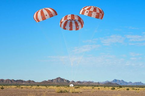 Orion’s three main orange and white parachutes help a representative model of the spacecraft descend through sky above Arizona, where NASA engineers tested the parachute system on Sept. 13 at the U.S. Army Proving Ground in Yuma. (NASA/Rad Sinyak)