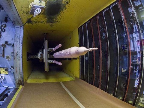 To understand the aerodynamic forces as booster separation motors fire and push the solid rocket boosters away from the rocket’s core, engineers at NASA's Langley Research Center are testing a 35-inch SLS model in Block 1B 105-metric ton evolved configuration in the Unitary Plan Wind Tunnel using a distinct pink paint. (Dave Bowman / NASA)