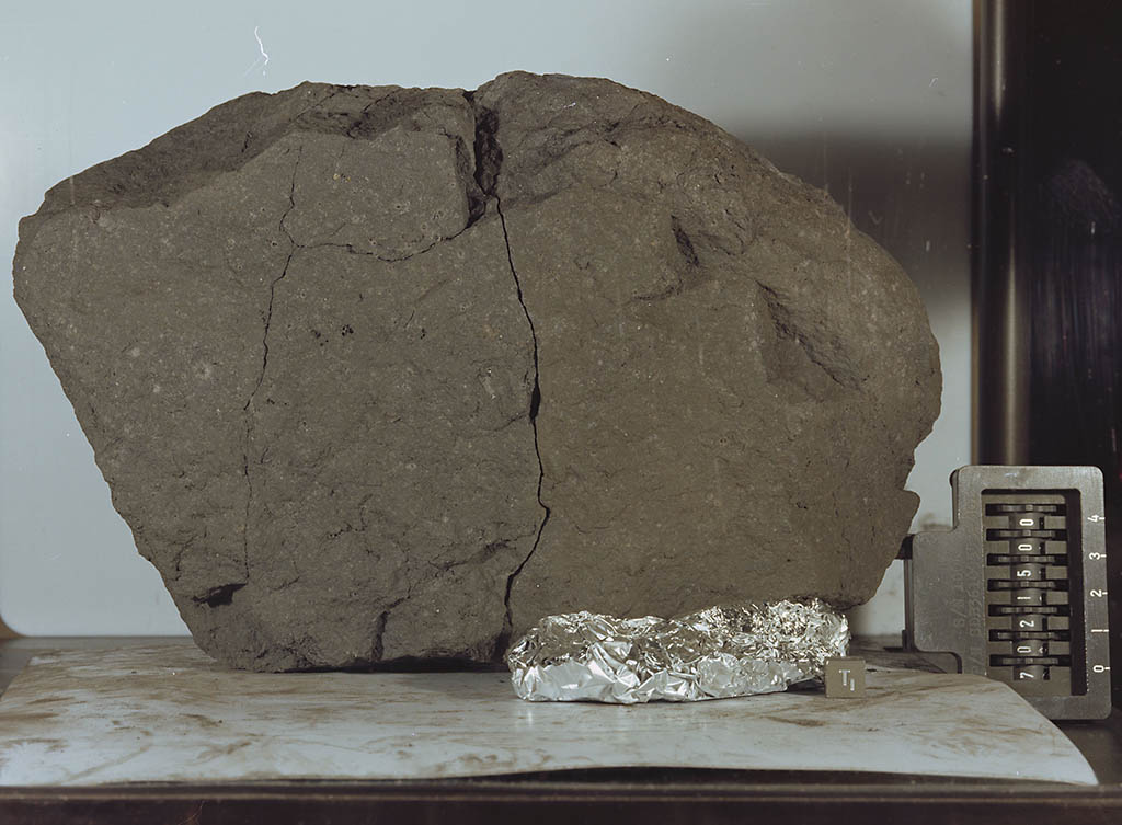 Lunar Sample 70215 was retrieved from the Moon’s surface and returned by NASA's Apollo 17 crew. The sample is a basaltic lava rock similar to lava found in Hawaii. It crystallized 3.84 billion years ago when lava flowed from the Camelot Crater. Sliced off a parent rock that originally weighed 8,110 grams, the sample weighs 14 grams, and is very fine grained, dense and tough. (NASA)