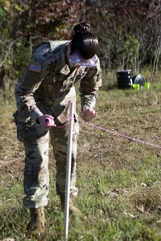 Spc. Amanda Jacobsen, a medic with Headquarters and Headquarters Battalion, Division Artillery, 101st Airborne Division, ties off string to create a fence around a notional chemical spill as part of a field exercise during a preventative medicine course October 26, 2017. The course focused on expanding the skillset of medics and reviewed topics for brigade preventive medicine teams. (Sgt. Samantha Stoffregen, 101st Airborne Division (Air Assault) public affairs) 