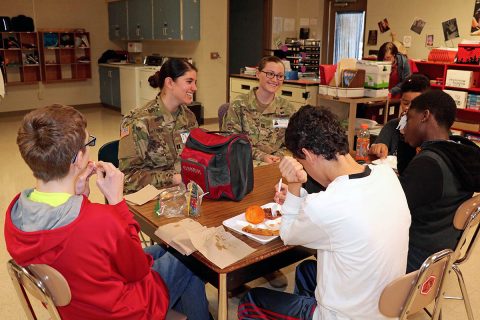 Blanchfield Army Community Hospital Soldiers, Capt. Lilly Vanek and Capt. Breanna Price talk with students from Northeast Middle School during lunch, Feb. 14. Soldiers and civilians from Blanchfield volunteer at the middle school through the Partners in Education program. Partners in Education works to unite schools with local businesses and organizations for the benefit of the entire community. (U.S. Army photo by Maria Yager) Blanchfield Army Community Hospital Soldiers, Capt. Lilly Vanek and Capt. Breanna Price talk with students from Northeast Middle School during lunch, Feb. 14. Soldiers and civilians from Blanchfield volunteer at the middle school through the Partners in Education program. Partners in Education works to unite schools with local businesses and organizations for the benefit of the entire community. (U.S. Army photo by Maria Yager)