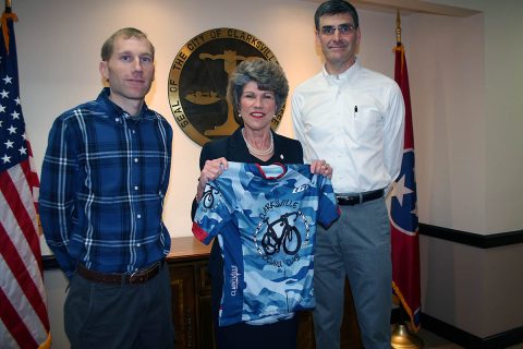 Clarksville Cycling Club members Lawrence Mize and Alex King present Clarksville Mayor Kim McMillan with an official club riding jersey during a recent meeting at City Hall. 