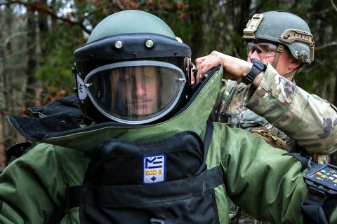 Staff Sgt. Jason McClure, an explosive ordnance disposal team leader with 717th Ordnance Company (Explosive Ordnance Disposal), 184th Ordnance Battalion (EOD), 52nd Ordnance Group (EOD), 20th Chemical, Biological, Radiological, Nuclear and high-yield Explosive Command, is assisted by Spc. Jared Hopson, a team member from the same unit, to put on a bomb suit on the training areas of Fort Campbell, Ky., Feb. 22, 2018. (U.S. Army photo by Pfc. Jay Diaz) 