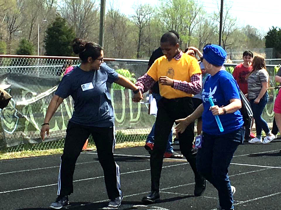 Blanchfield Army Community Hospital Soldier Sgt. Norma Arevalo and Northeast Middle School education assistant Janet Hildebrandt encourage a student-athlete participating in the 100-yard dash at the Special Olympics of Greater Clarksville Spring Games, April 13. (U.S. Army photo by Staff Sgt. Victoria Romero)