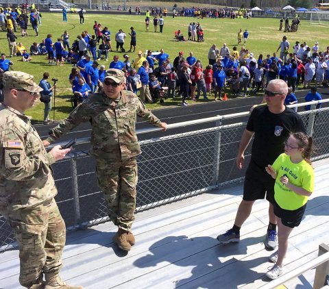 Fort Campbell Warrior Transition Battalion staff, 1st Sgt. Steve Peters and his daughter Abbigail, talk with Soldiers from the Battalion who came out to support Abbigail and other student-competitors from her school at the Special Olympics of Greater Clarksville Spring Games, April 13. Abbigail took first place in the Softball Throw and third place in the 50 meter run. (U.S. Army photo by Sgt. 1st Class Elizabeth Mercedes)