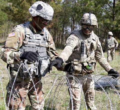 Pvt. Ivan Santiago-Velazquez and Sgt. Joseph Otatti, both from 2nd Platoon, Alpha Company, 39th Brigade Engineer Battalion, 2nd Brigade Combat Team, 101st Airborne Division (Air Assault), work together to separate concertina wire during a weekly Engineer training exercise, April 18 on Fort Campbell, KY. The concertina wire is used to construct a Triple Stand Concertina Wire Obstacle, which reinforces counter-mobility. (U.S. Army photo by Pfc. Beverly Roxane Mejia, 40th Public Affairs Detachment)