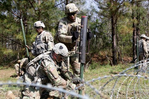 Pvt. Brandon Lehner, Spc. Zachary Cockrell and Sgt. Jose Acosta from 2nd Platoon, Alpha Company, 39th Brigade Engineer Battalion, 2nd Brigade Combat Team, 101st Airborne Division (Air Assault) drive pickets into the ground with a picket pounder during a platoon counter-mobility training event, April 18 on Fort Campbell, KY. During this training the soldiers familiarize themselves on how to construct a Triple Strand Concertina Wire Obstacle. (U.S. Army photo by Pfc. Beverly Roxane Mejia, 40th Public Affairs Detachment)