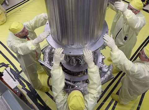 NASA and NNSA engineers lower the wall of the vacuum chamber around the Kilowatt Reactor Using Stirling TechnologY (KRUSTY system). The vacuum chamber is later evacuated to simulate the conditions of space when KRUSTY operates. (Los Alamos National Laboratory)