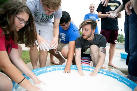 Austin Peay State University Department of Physics, Engineering and Astronomy graduate Jonathan Bunton, center, explains to Governor's School students what's happening with the corn starch-water mixture.