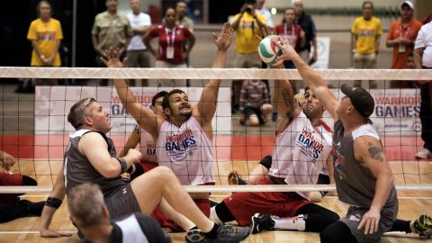 SOCOM Maj. Adam Ziegler, left, and SOCOM MSgt. Benjamin Brodt, right, battle Marine Corps veteran LCpl. Matthew Grashen, left center, and LCpl. Michael Sousa Docarmo for the ball during their sitting volleyball game at the 2017 Department of Defense (DoD) Warrior Games in Chicago, Ill., July 1, 2017.  (Roger L. Wollenberg)