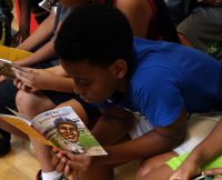 A young boy begins reading his new book during the kick-off event for Read20 Book Patrol at the Burt-Cobb Community Center July 9, 2018. Read20 Book Patrol is a program that is encouraging young children to read at least 20 minutes a day, while partnering with law enforcement to build positive relationships with officers in Tennessee communities.