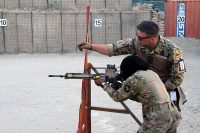 German Sgt.1st Class Michael Michna, a combat medic and non-commissioned officer in charge of the “Schutzenschnur” event coaches Pfc. Winshelle Pierre, an automated logistics specialist with the 101st Resolute Support Sustainment Brigade while she fires the HKG36 rifle at Maholic Range, on Bagram Airfield, Afghanistan, September 14th, 2018. (Spc. Alexes Anderson, 101st Airborne Division (AA) Sustainment Brigade Public Affairs)