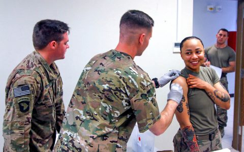 Specialist Phillip Pounders, a combat medic, assigned 101st Resolute Support Sustainment Brigade, inoculates Sgt. Brianna Sherpa, a construction equipment repair specialist, with the influenza vaccine at Bagram Airfield, Afghanistan, Oct. 17. (U.S. Army photo by Spc. Alexes Anderson) 