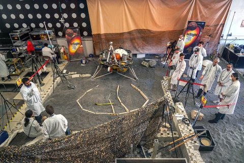 Engineers in Pasadena, California, sculpt a gravel-like material to mimic the terrain in front of NASA's InSight lander on Mars. Recreating the exact conditions will allow them to practice setting down the lander's instruments here on Earth before it's done on Mars. (NASA/JPL-Caltech/IPGP)