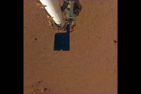 An image of InSight's robotic arm, with its scoop and stowed grapple, poised above the Martian soil. The image was received on Dec. 4, 2018 (Sol 8). (NASA/JPL-Caltech)