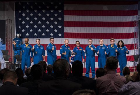 The first U.S. astronauts who will fly on American-made, commercial spacecraft to and from the International Space Station, wave after being announced, Friday, Aug. 3, 2018 at NASA's Johnson Space Center in Houston, Texas. The astronauts are, from left to right: Victor Glover, Mike Hopkins, Bob Behnken, Doug Hurley, Nicole Aunapu Mann, Chris Ferguson, Eric Boe, Josh Cassada and Suni Williams. (NASA/Bill Ingalls)