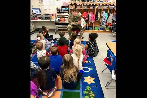 Pvt. 1st Class William Medellin, a medic assigned to Headquarters Company, 1st Battalion, 187th Infantry Regiment, 3rd Brigade Combat Team, 101st Airborne Division (Air Assault) reads to the kindergarten class during a visit to South Christian Elementary School Jan. 11. (Courtesy Photo)