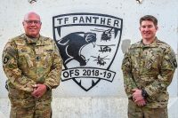 Command Sgt. Maj. John Cole, senior enlisted advisor, and CW2 Bradley Cole, AH-64 Apache Helicopter pilot, with 1st Battalion, 130th Aviation Regiment (Attack Reconnaissance Battalion), Task Force Panther, of the North Carolina National Guard, assigned to 101st Combat Aviation Brigade, 101st Airborne Division (Air Assault), pose for a picture at Kandahar Airfield, Afghanistan Dec. 29, 2018. (Sgt. Steven Lopez, 101st Combat Aviation Brigade)