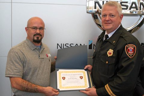 Clarksville Fire Rescue District Chief Daniel Moore presents a Certificate of Recognition to Erik Ranallo, shop foreman at Mathews Nissan, for his help in extracting a woman from a vehicle.