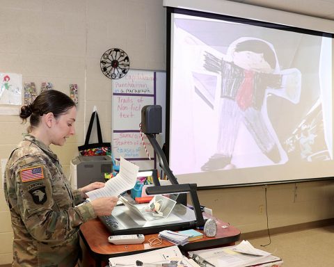 Staff Sgt. Jamie Hendzel, a combat medical specialist assigned to Blanchfield Army Community Hospital, reads a Flat Stanley letter to students at Northeast Middle School Jan. 16. Soldiers and federal service employees from Blanchfield adopted Flat Stanley's from Northeast over the holidays and documented his experiences for the students to read. (Maria Yager, BACH)