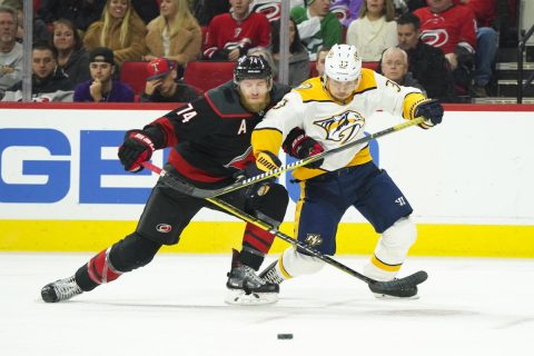 Carolina Hurricanes defenseman Jaccob Slavin (74) and Nashville Predators right wing Viktor Arvidsson (33) go after the loose puck during the first period at PNC Arena. (James Guillory-USA TODAY Sports)