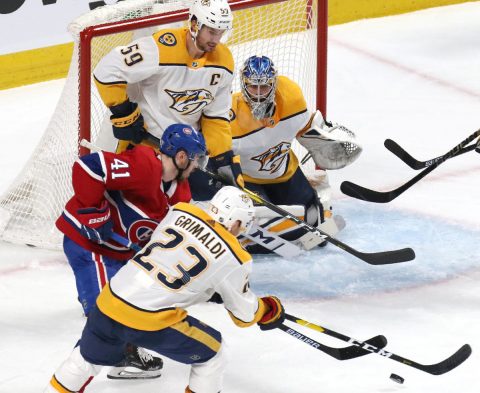 Jan 5, 2019; Montreal, Quebec, CAN; Nashville Predators center Rocco Grimaldi (23) and Montreal Canadiens left wing Paul Byron (41) battle for the puck in front of goaltender Juuse Saros (74) during the first period at Bell Centre. Mandatory Credit: Jean-Yves Ahern-USA TODAY Sports