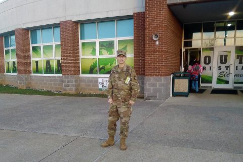 Spc. Grayson Sauer, an infantryman with C Co., 1st Battalion, 187th Infantry Regiment, 3rd Brigade Combat Team, poses in front of South Christian Elementary. (U.S. Army Photo by 1st Lt. John Radigan)