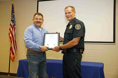 Clarksville Police Chief Al Ansley congradulates Office Russ Baker on his 39 years of service to the department.