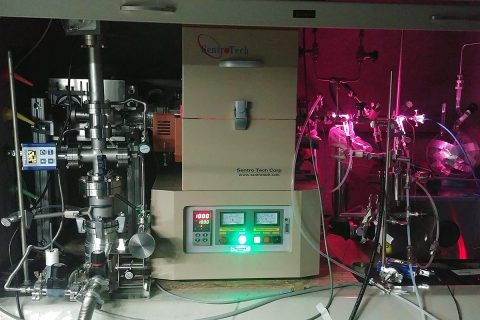 JPL scientists used the "oven" (center) to heat a mixture of hydrogen and carbon monoxide and subject it to UV radiation, generated by a hydrogen gas discharge lamp. The lamp radiates both visible light (the pink glow) and UV light, which enters the gas container inside the oven via a window on the right side. (NASA/JPL-Caltech)