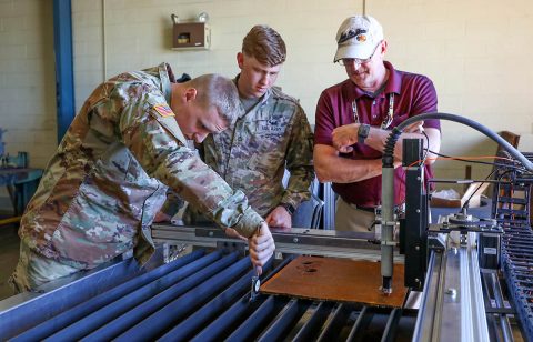 Soldiers of the 584th Maintenance Company, 129th Combat Sustainment Support Battalion, 101st Sustainment Brigade, 101st Airborne Division (Air Assault), measure the thickness of a piece of sheet metal, while civilian engineering instructors demonstrate how to use the plasma cutter machine.  (Staff Sgt. Caitlyn Byrne, 101st Sustainment Brigade Public Affairs) 