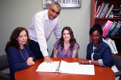 Keith Lampkin, director of the Clarksville Office of Housing & Community Development, discusses projects with staff members, from left, Jean Adcock, Brittney Cates and Lisa Walker. 