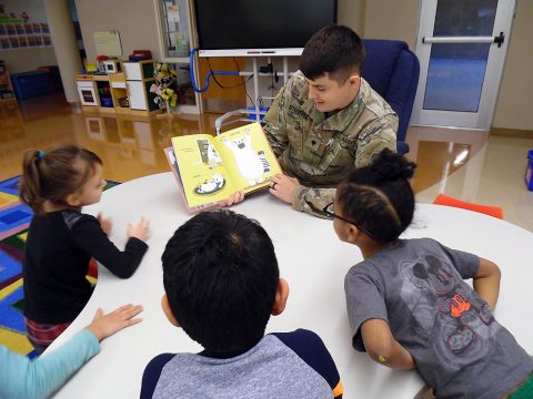 Spc. Kyle Stouffer, a medic from the 551st Military Police Company, 716th Military Police Battalion, captivates students at Marshall Elementary School (MES) for “Read Across America.” MES is an official partner school for the 716th MP BN on the installation. (101st Airborne Division (AA) Sustainment Brigade Public Affairs)