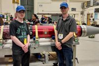 Austin Peay State University students Zach Hill (L) and Zach Givens (R) pose with the rocket that will carry their experiment to space. (APSU)