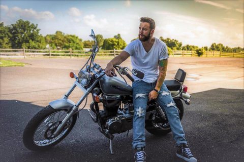 Biker sitting on the side of the road.