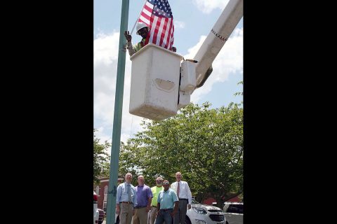 Roger Williams, a Clarksville Street Department technician, places a new American Flag at City Hall while Mayor Joe Pitts, Street Department staff Tommy Allbert, Tim Halbrooks and Brian Nelson, and Military Liaison Bill Harpel show pride in the effort to beautify the City with our country’s most patriotic symbol.