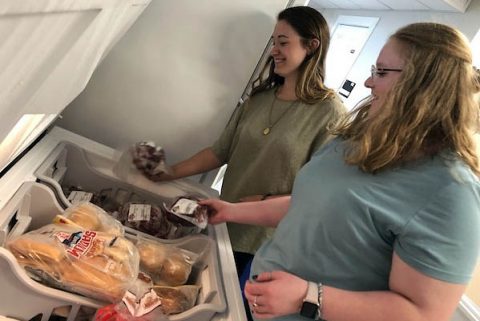 Maddie MacGalliard, food pantry manager, and student Janesa Wine load donated beef into a freezer. (APSU)