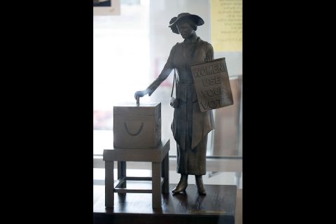 A woman casts her first vote in this miniature replica of the statue. (APSU)