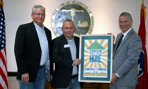 Kevin Underwood, left, president of  Habitat for Humanity of Montgomery County, and Executive Director Rob Selkow present a Hatch Show Print celebrating Clarksville and “home” to Clarksville Mayor Joe Pitts. The print is available for $20 at Habitat ReStore, 404 Madison Street.