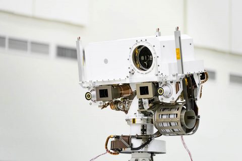 This image, taken in the Spacecraft Assembly Facility's High Bay 1 at the Jet Propulsion Laboratory in Pasadena, California, on July 23, 2019, shows a close-up of the head of Mars 2020's remote sensing mast. The mast head contains the SuperCam instrument (its lens is in the large circular opening). (NASA/JPL-Caltech)