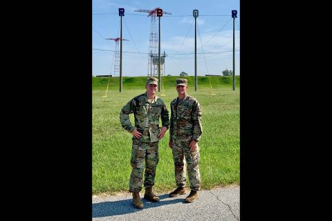 Austin Peay State University junior Alden Marvin, right, stands in front of the Army Airborne School towers. (APSU)