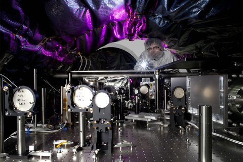 An optical engineer at NASA's Jet Propulsion Laboratory, in Pasadena, California, Camilo Mejia Prada, shines a light on the interior of a testbed for an instrument called a coronagraph that will fly aboard the WFIRST space telescope. (NASA/JPL-Caltech/Matthew Luem)