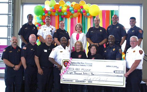 Clarksville Fire Rescue Chief Freddie Montgomery, front row center, joins with members of Fire Rescue to present a check for $8,000 to the YMCA's After Breast Cancer program at Thursday’s Tickle Me Pink event at the Wilma Rudolph Event Center. Susan Harris and Angela Moody, both to Montgomery’s right, lead CFR’s annual T-shirt fundraiser which benefits ABC. Clarksville First Lady Cynthia Pitts, back row center, offered the invocation at Tickle Me Pink.