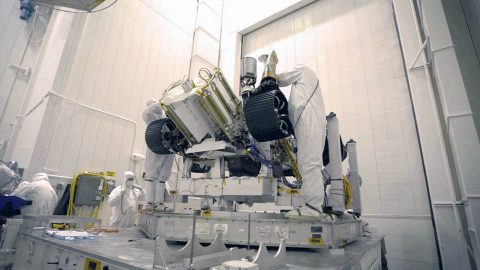 Bunny-suited engineers remove the inner layer of protective foil on NASA's Mars 2020 rover after it was moved to a different building at JPL for testing. (NASA)