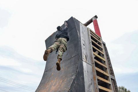 Capt. Chandler Smith, a member of the U.S. Army Warrior Fitness Team, hangs from a tower while conducting the 5th Special Forces Group obstacle course at Fort Campbell, Ky., Oct. 25 2019. Green Berets held multiple events throughout the day to show the physical fitness aspect of a special operations unit. (Sgt. Matthew Crane, 5th Special Forces Public Affairs Office)