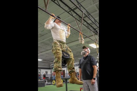 Professional CrossFit athlete Noah Olsen performs weighted pull-ups during an event at the 5th Special Forces gym, Fort Campbell, Ky., Oct. 25 2019. Green Berets held multiple events throughout the day to show the physical fitness aspect of a special operations unit. (Sgt. Matthew Crane, 5th Special Forces Public Affairs Office)