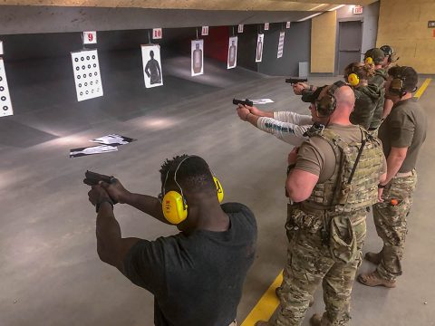 Capt. Chandler Smith, a member of the U.S. Army Warrior Fitness Team, along with professional CrossFit athlete Noah Ohlsen learn how to properly shoot handguns at the 5th Special Forces Group (Airborne) indoor shooting range, Fort Campbell, Ky., Oct. 25 2019. The Green Berets held multiple events throughout the day to show the different aspects of a special operations unit. (Sgt. Matthew Crane, 5th Special Forces Public Affairs Office)