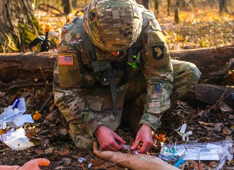 Second Lieutenant Shawn Ogden, a health services officer for 1st Battalion, 32nd Cavalry Regiment, 1st Brigade Combat Team, 101st Airborne Division (Air Assault), flushes an IV, Nov. 18, during a practice run for the Expert Field Medic Badge testing at Fort Campbell. The EFMB features rigorous tasks such as a 128-step patient evaluation. (Spc. Jeremy Lewis, 40th Public Affairs Detachment) 